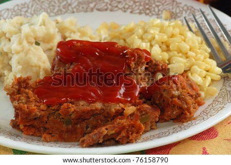Meatloaf dinner with corn and mashed potatoes.
