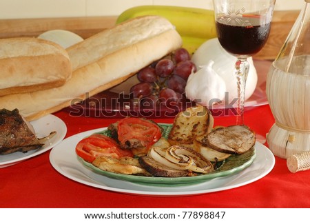 Beef Tenderloin on French bread with sliced tomato and sauteed onion; served with red wine in long-stem crystal glass.