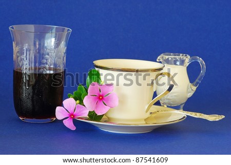 Feel good morning with cold glass of grape juice with coffee and cream on fine china and silver with crystal glass.  Flower completes the feel of the image.