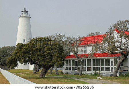 Ocracoke Lighthouse on North Carolina Outer Banks with contrasting red roof of light keeper\'s house.