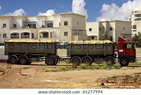 Truck with trailer with buildings as a background