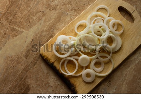 white onion rings lie on a marble background