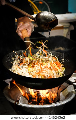 street food. fried noodles in a wok with chicken and shrimp on the open fire.Flat Lay, Chinese style