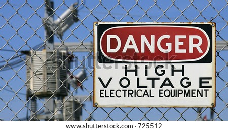 Danger Sign hanging on a fence. White, black and red sign warning of electrical hazard