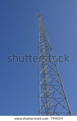 Steel frame tower against a blue sky. Tower is vertically framed and shot from below with plenty of open space for text.
