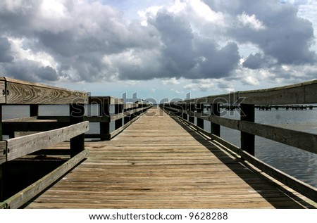Wooden pier advancing into the darkening horizon