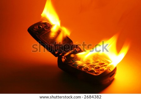 A burning cell phone against a colored background, as an abstract for burning up call time, or eliminating the phone in revenge for its cost.