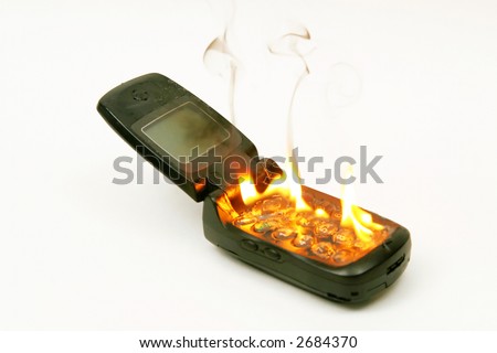 A burning cellphone against a white background, as an abstract for burning up call time, or eliminating the phone in revenge for its cost.
