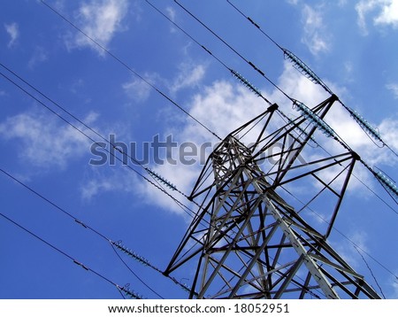 electricity pylon / tower with fluffy white clouds and blue sky background