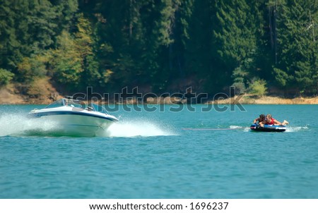 Boat pulling two men on an inner tube