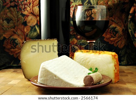 Three cheeses with a bottle and glass of red wine