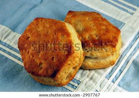 Two buttermilk biscuits on a vintage pale blue table linen