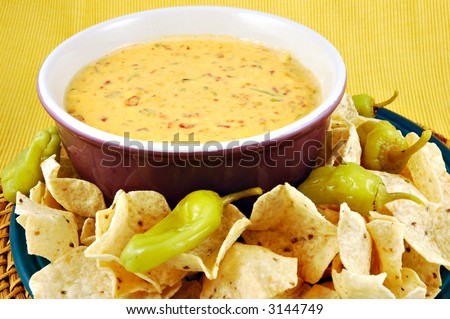 stock-photo-bowl-of-warm-queso-cheese-dip-with-a-plate-of-tortilla-chips-3144749