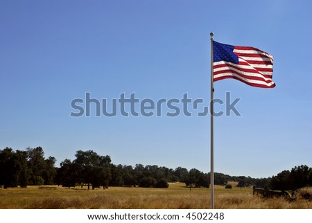 American flag billowing in a deep blue clear sky in Gold Rush Country in the Sierra Foothills of California