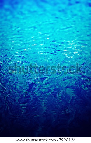 Ripples on deep clear blue water in a swimming pool