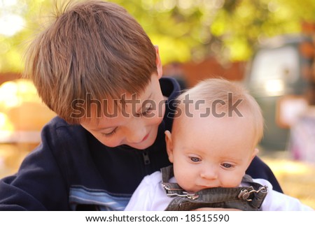 Big brother holding his baby brother at a farm