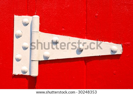 Painted white door hinge on red painted door