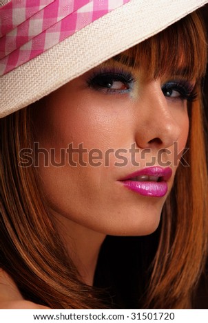 Young brunette woman wearing pink and white fedora hat