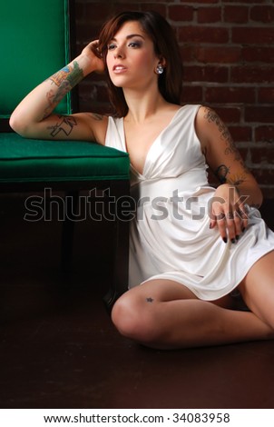 Young tattooed woman with green wooden chair