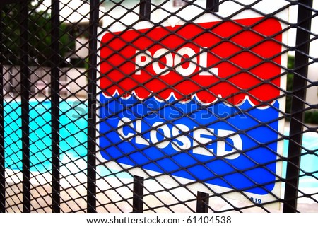 Pool closed sign on fence outside apartment complex swimming pool
