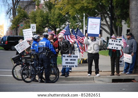 SACRAMENTO, CALIFORNIA - FEBRUARY 26: Law Enforcement officers talk to Tea Party protesters rallying in Sacramento, California on February 26, 2011