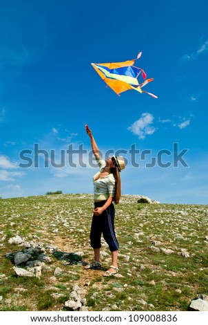 woman with kite against the blue sky