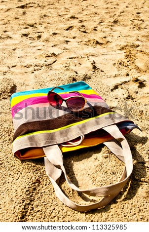 bag and glasses on the sand
