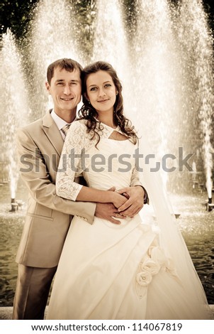 bride and groom against the fountain