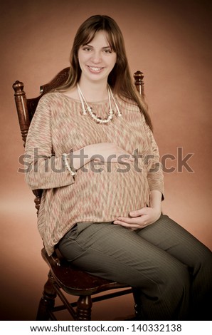 elegant pregnant woman sitting on a chair