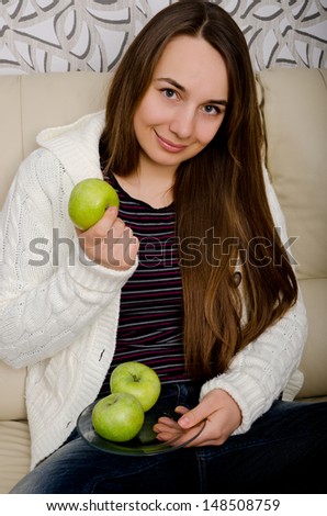 woman with apple sitting indoors
