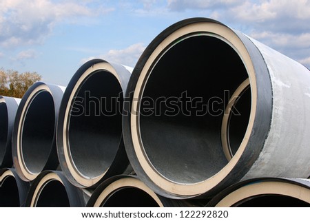 Stack of pipes of the big diameter against the cloudy sky