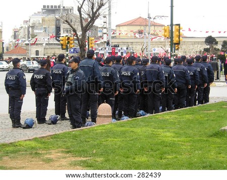 Turkish police at Taksim square standing and listening to their national anthem-hymn.