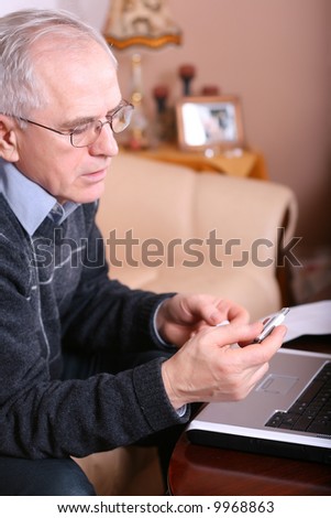 Senior man using a memory stick and a laptop