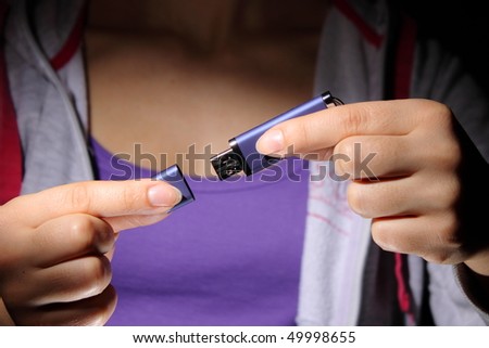 A young woman holding a USB flash memory stick