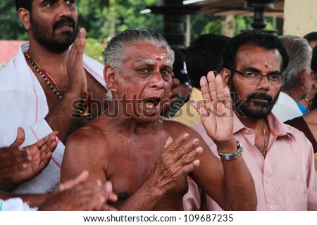ARANMULA, INDIA - AUGUST 5:  A devotees sing traditional song at  the mass feast ceremony as part of the boat race celebration held at Parthasarathy temple on August 05,2012 in Aranmula, India.