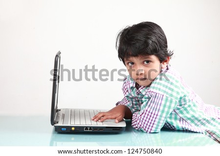 Boy looks while he types on a laptop