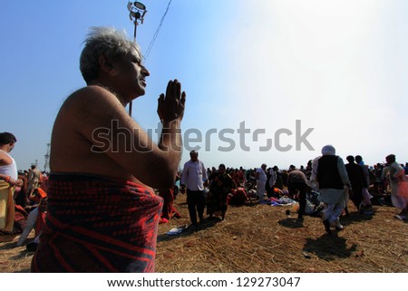 ALLAHABAD - FEB 08: A devotee prays to sun after his holy bath at Kumbh Mela on February 08, 2013 in Allahabad, India. Kumbh Mela is considered as the largest human gathering in the world.