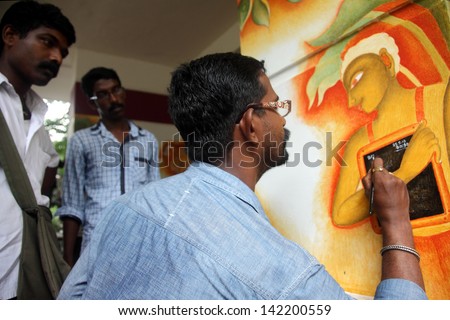 KOTTAYAM, INDIA - MAY 25:Mural artist Suresh Muthukulam paints on  the wall during the International Mural painters camp organized by Cultural Department of Kerala on May 25,2013 in Kottayam, India.