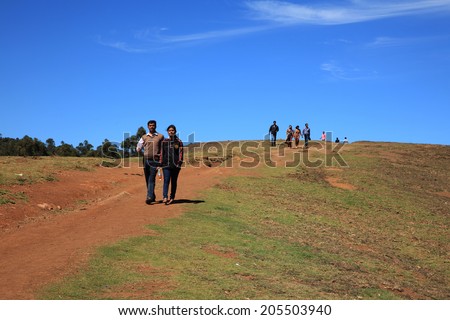 OOTY, INDIA - DEC 05: Unidentified group of tourists walk down the hills on December 05, 2012 in Ooty, India. Ooty is a popular tourist destination in South India also known as Queen of hill stations.