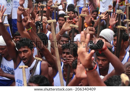 PAYIPPAD, INDIA - SEPT 18: Oarsmen of a snake boat team cheer up during the Payippad Boat race on September 18, 2013 in Payippad, Kerala, India. Boat races are the major sporting events in Kerala.