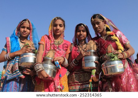 JAISALMER, INDIA - FEB 01: Traditionally dressed Rajasthani dancers holding pots perform during a cultural procession for Desert festival held on February 01, 2015 in Jaisalmer, Rajasthan,India.