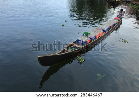 ALLEPPEY, INDIA -APR 14 : A boat man transport soft drink bottles in his boat in the backwaters on April 14, 2010 in Alleppey, India. People of the region depend on boats for their transporting needs