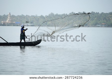 CHERAI, INDIA - MAY 10 : Unidentified fishermen in a boat catch fish by throwing net in to the backwaters in a misty morning on May 10, 2011 in Cherai,Kerala, India.