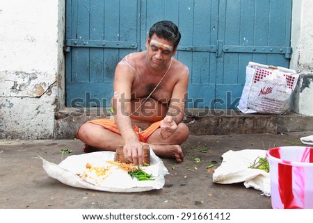 CHENNAI, INDIA - FEB 09 : An unidentified Brahmin priest sits outside the Kapaleeshawar temple on February 9, 2012 in Chennai, India. Brahmins are the appointed priests in most of the temples in India