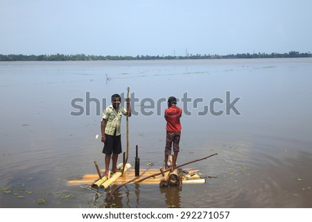 KUTTANAD, INDIA - MAY 26 : Unidentified boy rows a raft made out of banana stem in the backwaters on May 26, 2012 in Kuttanad,Kerala, India. Kuttanad is known as the lowest altitute region in India.