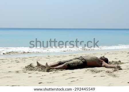 KUTTANAD, INDIA - FEB 13 : An unidentified tourist takes mud bath which is considered to be good for the health in the Radha Kkrishna beach on February 13, 2012 in Havelock islands, Andamans,India.