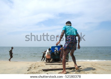 ALLEPPEY, INDIA - NOVEMBER 3 : Fishermen bringing their boat to the shore of Arabian sea November 3, 2009 in Alleppey, India.