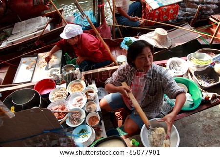 RATCHABURI, THAILAND - FEB 13: A woman makes Thai food at Damnoen Saduak floating market on February 13, 2011 in Ratchaburi, Thailand. Its popular for old and  traditional way to sell and buy food.