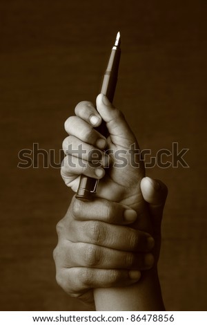 Old hand  lifts a young hand with a pen