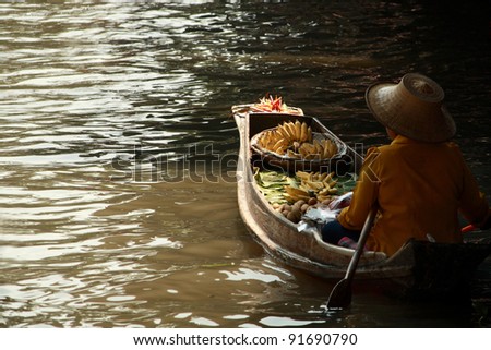 RATCHABURI, THAILAND - FEB 13: A fruit seller rows boat in Damnoen Saduak floating market on February 13, 2011 in Ratchaburi, Thailand. Its famous for old and traditional way to sell and buy goods.